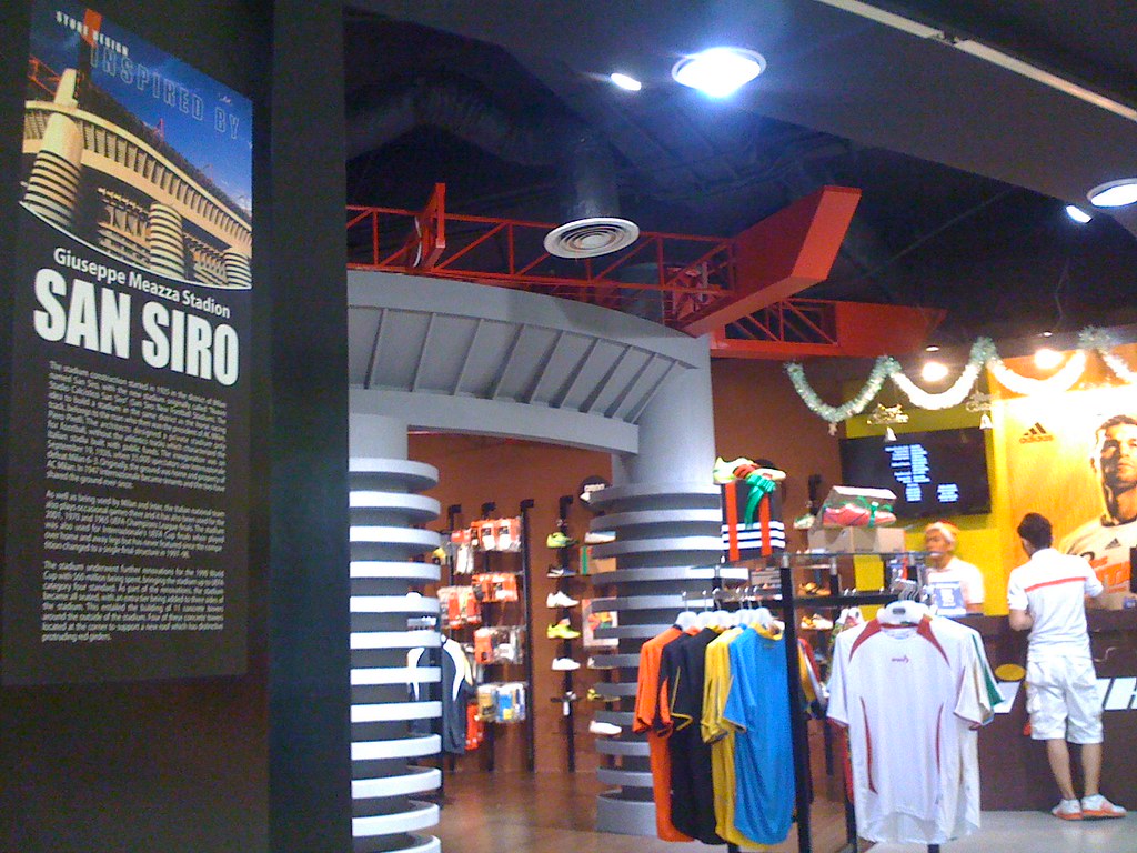 Interior de la tienda FISIK en Tunjungan Plaza con prendas exhibidas y clientes recorriendo el local.